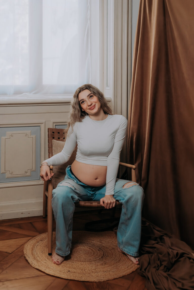 Těhotná žena sedící na židli v elegantním interiéru