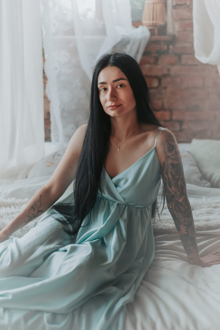 elegantní boudoir focení ženy v saténových šatech u okna