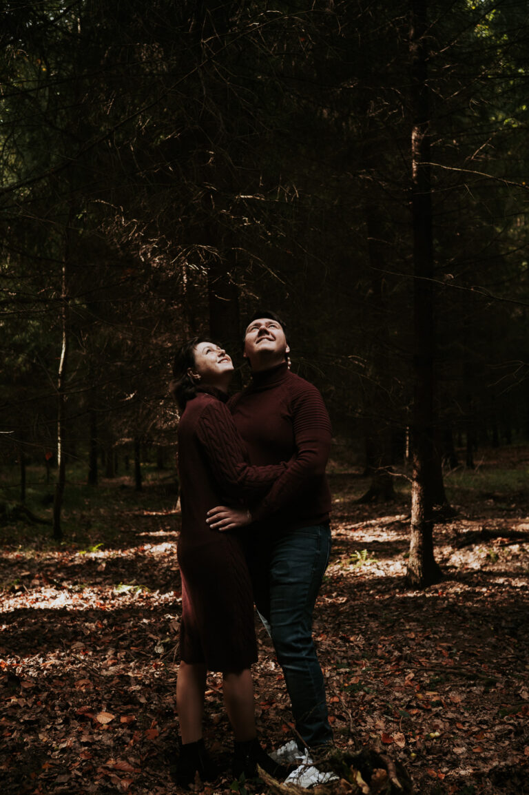 Zamilovaný pár se objímá v lese při romantickém párovém focení v přírodě.