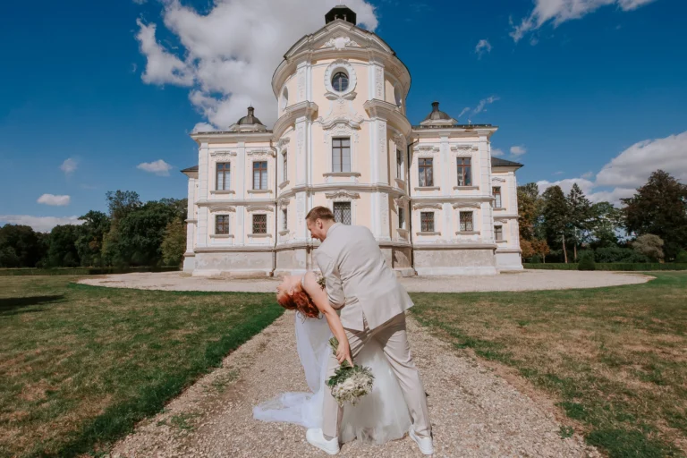 Novomanželé před barokním kostelem během svatebního focení.