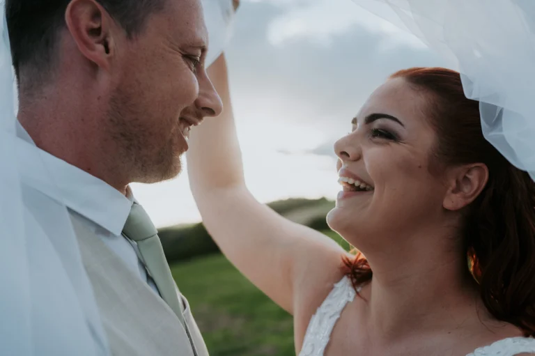Usměvavá nevěsta během romantického svatebního focení při západu slunce.